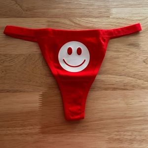 NWOT Sexy Red Thong Underwear with White Glow in the Dark Happy Face Print.